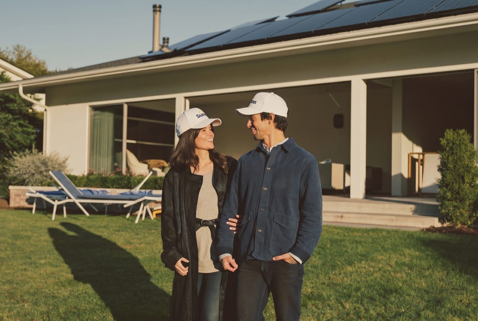 A couple outside a solar-powered home in the afternoon sun